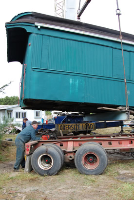Crane sets car 5 down on a highway truck trailer